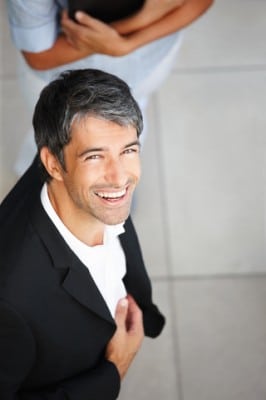 A very happy well dressed man because of the cosmetic dentistry he recieved