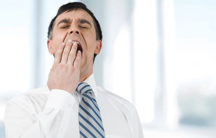 Businessman yawning in his office