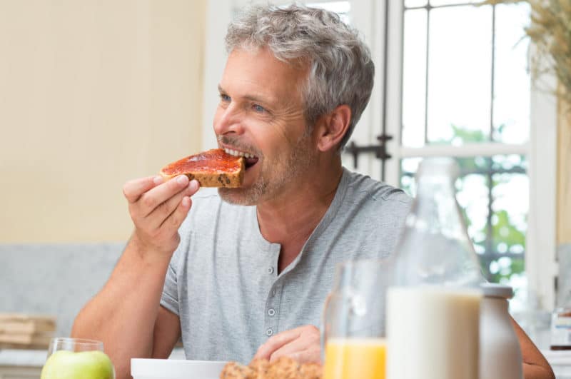 man eating breakfast toast with jam