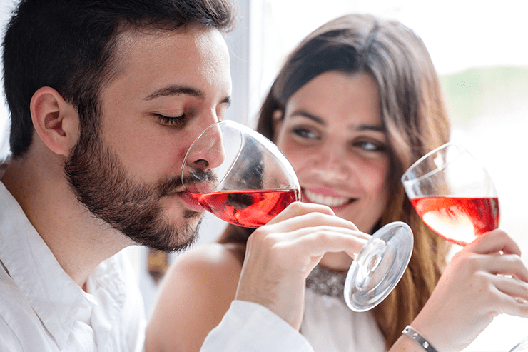 Two young adults drinking red wine