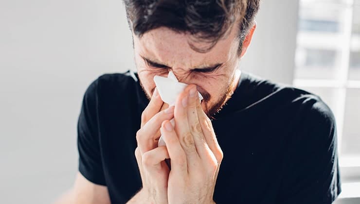 Young man with a handkerchief. Is it an infection in his sinuses or a bad tooth