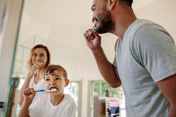 A young family spends the time brushing their teeth together to promote good oral hygiene. The amount of fluoride in your toothpaste comes into question as does it better prevent cavities or not.