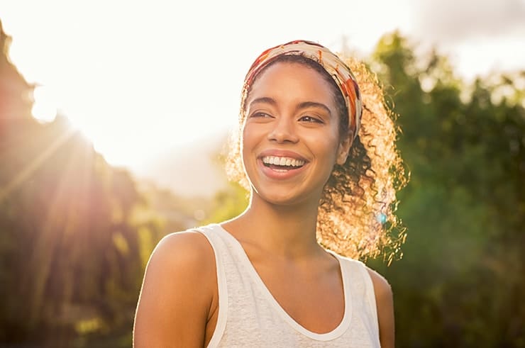 Young Sydney, Australia woman smiling in the sunset showing off her veneer where she use to have a chipped tooth. It's more than cosmetic!