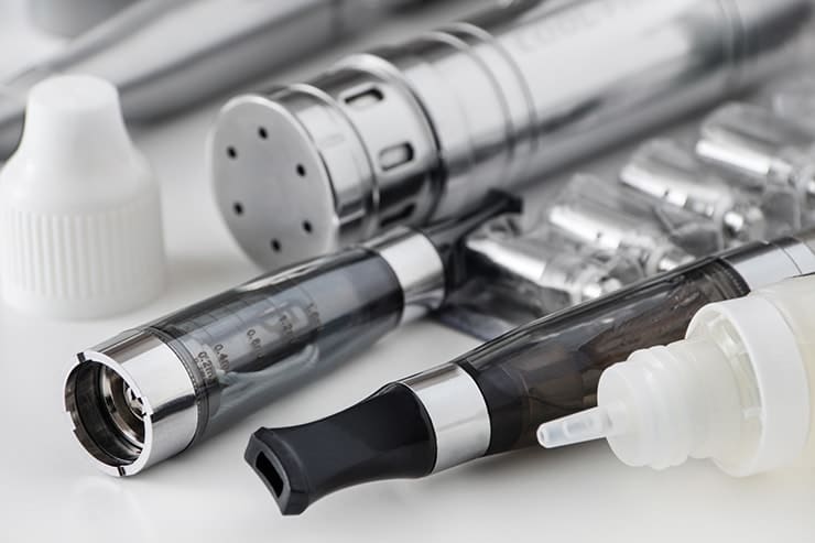 E-Cigarette and vaping juice sitting on a countertop. Even Nicotine-free E-cigarettes Are Bad for Oral Health