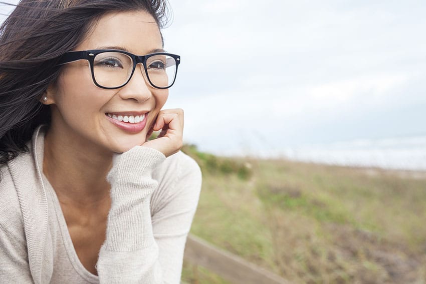 cute Asian woman looking out on the beautiful ocean