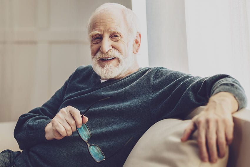 older man relaxing on his couch at home