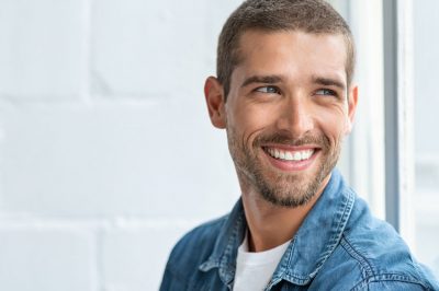 handsome man showing off his beautiful smile thanks to cosmetic dentistry