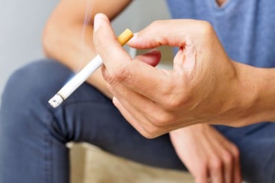 close up of a man's hand with a cigarette