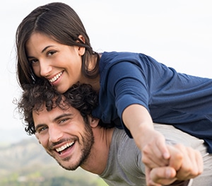 Man giving woman a piggy back ride.