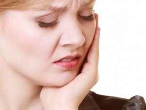 Young woman in discomfort apparently from jaw pain