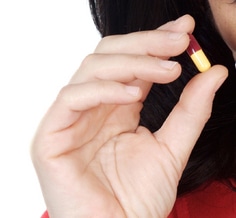 Photo of a hand holding a pill