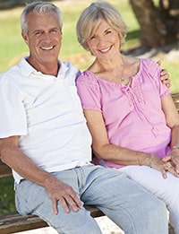 Happy, older couple sitting on a park bench